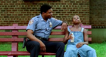 Movie still from “Clockers” (1995), directed by Spike Lee – A police officer sitting next to a woman on a park bench; Medium shot, Low angle
