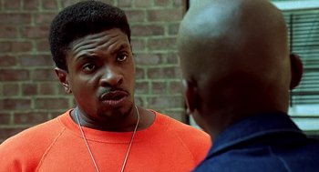 Movie still from “Clockers” (1995), directed by Spike Lee – A man in an orange shirt talking to another man in an orange shirt; Close Up shot, Over the shoulder angle
