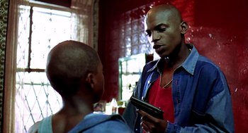 Movie still from “Clockers” (1995), directed by Spike Lee – A bald man is looking at a cell phone; Close Up shot, Low angle