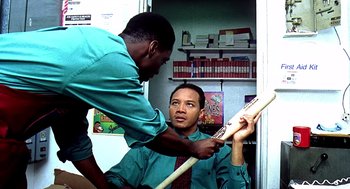 Movie still from “Clockers” (1995), directed by Spike Lee – Two men in green shirts and ties one is holding a baseball bat; Medium shot, Over the shoulder angle