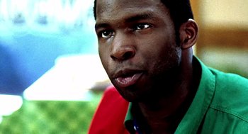 Movie still from “Clockers” (1995), directed by Spike Lee – A man's face in a green shirt; Close Up shot, Over the shoulder angle