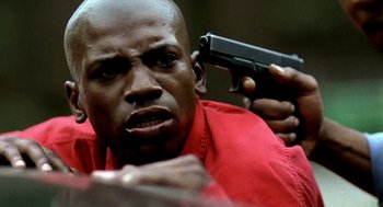 Movie still from “Clockers” (1995), directed by Spike Lee – A man in a red shirt holding a gun up to his face; Extreme Close Up shot, Low angle