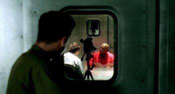 Movie still from “Clockers” (1995), directed by Spike Lee – Two men sitting on a train looking at each other through a window; Medium shot, Over the shoulder angle