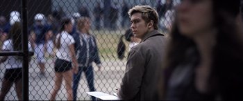 Movie still from “Death Note” (2017), directed by Adam Wingard – A man standing in front of a chain link fence holding papers; Close Up shot, Over the shoulder angle
