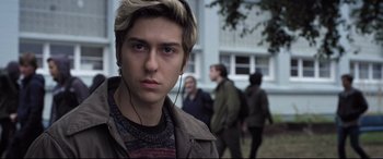 Movie still from “Death Note” (2017), directed by Adam Wingard – A young man with headphones in front of a group of people; Close Up shot, Low angle