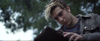 Movie still from “Death Note” (2017), directed by Adam Wingard – A young man is looking at a book in the rain; Close Up shot, Low angle
