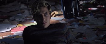 Movie still from “Death Note” (2017), directed by Adam Wingard – A young man with blonde hair is sitting in the dark; Medium shot, High angle