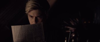Movie still from “Death Note” (2017), directed by Adam Wingard – A man is reading a newspaper in a dark room; Close Up shot, Over the shoulder angle