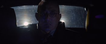 Movie still from “Death Note” (2017), directed by Adam Wingard – A man in a suit and glasses in a car; Close Up shot, Low angle