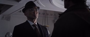 Movie still from “Death Note” (2017), directed by Adam Wingard – A man wearing a hat and glasses and a vest; Close Up shot, Low angle