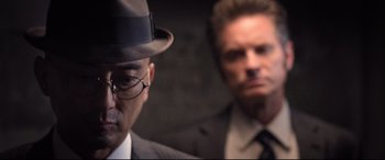 Movie still from “Death Note” (2017), directed by Adam Wingard – A man in a suit and a hat and a man in a suit and a hat; Close Up shot, Over the shoulder angle