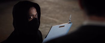 Movie still from “Death Note” (2017), directed by Adam Wingard – A hooded man holding a folder with a pair of scissors; Close Up shot, Over the shoulder angle