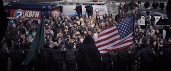 Movie still from “Death Note” (2017), directed by Adam Wingard – A large group of people gathered around a flag; Wide shot, High angle
