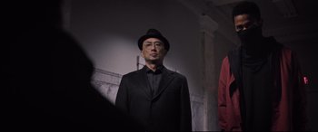 Movie still from “Death Note” (2017), directed by Adam Wingard – A man wearing a black hat and a black suit; Medium shot, Low angle