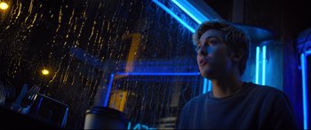 Movie still from “Death Note” (2017), directed by Adam Wingard – A young man standing in front of a rain shower; Medium shot, Low angle