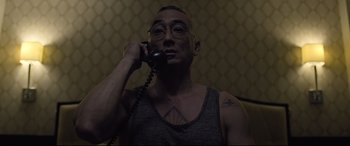 Movie still from “Death Note” (2017), directed by Adam Wingard – A man with tattoos talking on a phone; Close Up shot, Over the shoulder angle