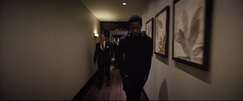 Movie still from “Death Note” (2017), directed by Adam Wingard – Two men walking down a long hallway in a hotel room; Medium shot, Low angle