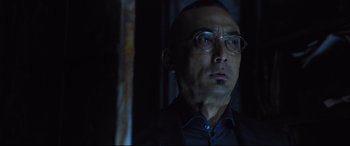 Movie still from “Death Note” (2017), directed by Adam Wingard – A man in a suit and glasses looking at the camera; Close Up shot, Low angle