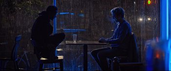 Movie still from “Death Note” (2017), directed by Adam Wingard – Two people sitting at a table in the rain; Wide shot, Over the shoulder angle
