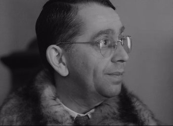 Movie still from “Closely Watched Trains” (1966), directed by Jirí Menzel – An older man wearing glasses and a fur coat; Close Up shot, High angle