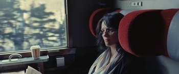 Movie still from “Clouds of Sils Maria” (2014), directed by Olivier Assayas – A woman sitting on a train looking out the window; Close Up shot, Over the shoulder angle