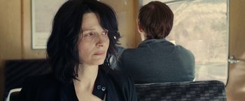 Movie still from “Clouds of Sils Maria” (2014), directed by Olivier Assayas – A woman sitting next to another woman on a train; Close Up shot, Over the shoulder angle