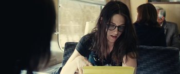 Movie still from “Clouds of Sils Maria” (2014), directed by Olivier Assayas – A woman sitting on a couch looking at a laptop; Medium shot, Over the shoulder angle