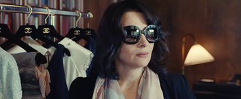 Movie still from “Clouds of Sils Maria” (2014), directed by Olivier Assayas – A woman wearing sunglasses and a scarf looking off into the distance; Close Up shot, Over the shoulder angle