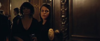 Movie still from “Clouds of Sils Maria” (2014), directed by Olivier Assayas – A woman standing in front of a mirror holding a drink; Close Up shot, Over the shoulder angle