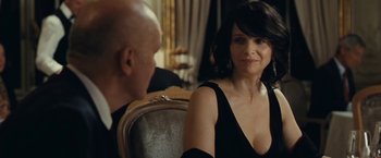 Movie still from “Clouds of Sils Maria” (2014), directed by Olivier Assayas – A woman in a black dress sitting next to a man in a black suit; Close Up shot, Over the shoulder angle