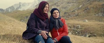 Movie still from “Clouds of Sils Maria” (2014), directed by Olivier Assayas – Two women sitting next to each other on a hill; Medium shot, Low angle