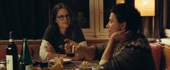 Movie still from “Clouds of Sils Maria” (2014), directed by Olivier Assayas – Two people sitting at a table with food; Medium shot, Over the shoulder angle