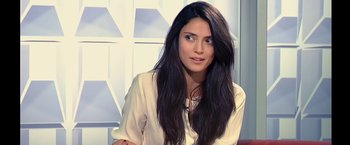 Movie still from “Clouds of Sils Maria” (2014), directed by Olivier Assayas – A woman with long black hair sitting in front of a window; Close Up shot, Over the shoulder angle