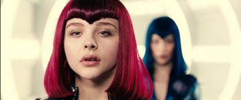 Movie still from “Clouds of Sils Maria” (2014), directed by Olivier Assayas – A girl with pink and blue hair looking at the camera; Close Up shot, Low angle