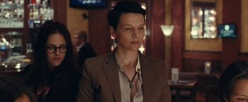 Movie still from “Clouds of Sils Maria” (2014), directed by Olivier Assayas – A woman with short hair wearing a suit and a necklace; Close Up shot, Over the shoulder angle