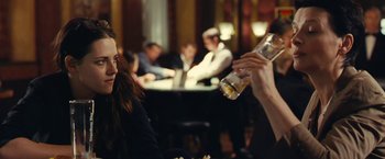 Movie still from “Clouds of Sils Maria” (2014), directed by Olivier Assayas – A man pouring beer into a woman's hand at a restaurant; Close Up shot, Over the shoulder angle