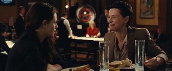 Movie still from “Clouds of Sils Maria” (2014), directed by Olivier Assayas – Two people sitting at a table with plates of food in front of them; Medium shot, Over the shoulder angle