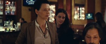 Movie still from “Clouds of Sils Maria” (2014), directed by Olivier Assayas – A woman standing next to another woman in a room; Close Up shot, Over the shoulder angle