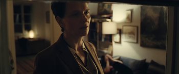 Movie still from “Clouds of Sils Maria” (2014), directed by Olivier Assayas – A woman standing in a living room looking at the camera; Close Up shot, Over the shoulder angle