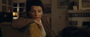 Movie still from “Clouds of Sils Maria” (2014), directed by Olivier Assayas – A woman sitting on a chair with her hand on her shoulder; Close Up shot, High angle