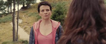 Movie still from “Clouds of Sils Maria” (2014), directed by Olivier Assayas – A woman in a pink shirt and a pink jacket; Close Up shot, Over the shoulder angle