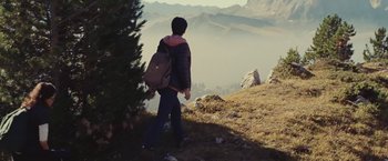 Movie still from “Clouds of Sils Maria” (2014), directed by Olivier Assayas – A person with a backpack walking up a hill; Wide shot, High angle