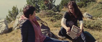 Movie still from “Clouds of Sils Maria” (2014), directed by Olivier Assayas – Two women sitting on the ground in the grass; Medium shot, Over the shoulder angle