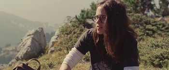 Movie still from “Clouds of Sils Maria” (2014), directed by Olivier Assayas – A young woman sitting on top of a hill; Close Up shot, Low angle
