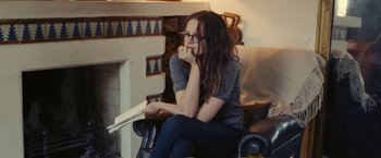 Movie still from “Clouds of Sils Maria” (2014), directed by Olivier Assayas – A woman sitting in a chair with her hand on her chin; Medium shot, Over the shoulder angle