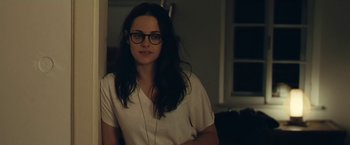 Movie still from “Clouds of Sils Maria” (2014), directed by Olivier Assayas – A woman wearing glasses sitting in a room; Close Up shot, Over the shoulder angle