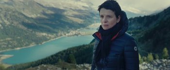 Movie still from “Clouds of Sils Maria” (2014), directed by Olivier Assayas – A woman standing on top of a mountain looking at the camera; Close Up shot, Low angle