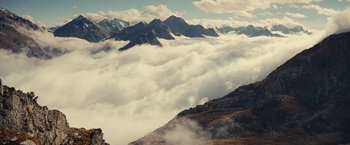 Movie still from “Clouds of Sils Maria” (2014), directed by Olivier Assayas – A view of a mountain range covered in clouds; Extreme Wide shot, Low angle