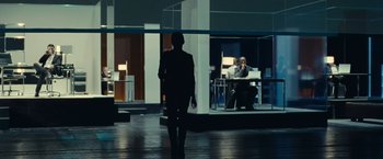 Movie still from “Clouds of Sils Maria” (2014), directed by Olivier Assayas – A man standing in front of two people in a room; Wide shot, Over the shoulder angle