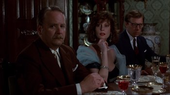 Movie still from “Clue” (1985), directed by Jonathan Lynn – A man and a woman sitting at a dinner table; Medium shot, Over the shoulder angle